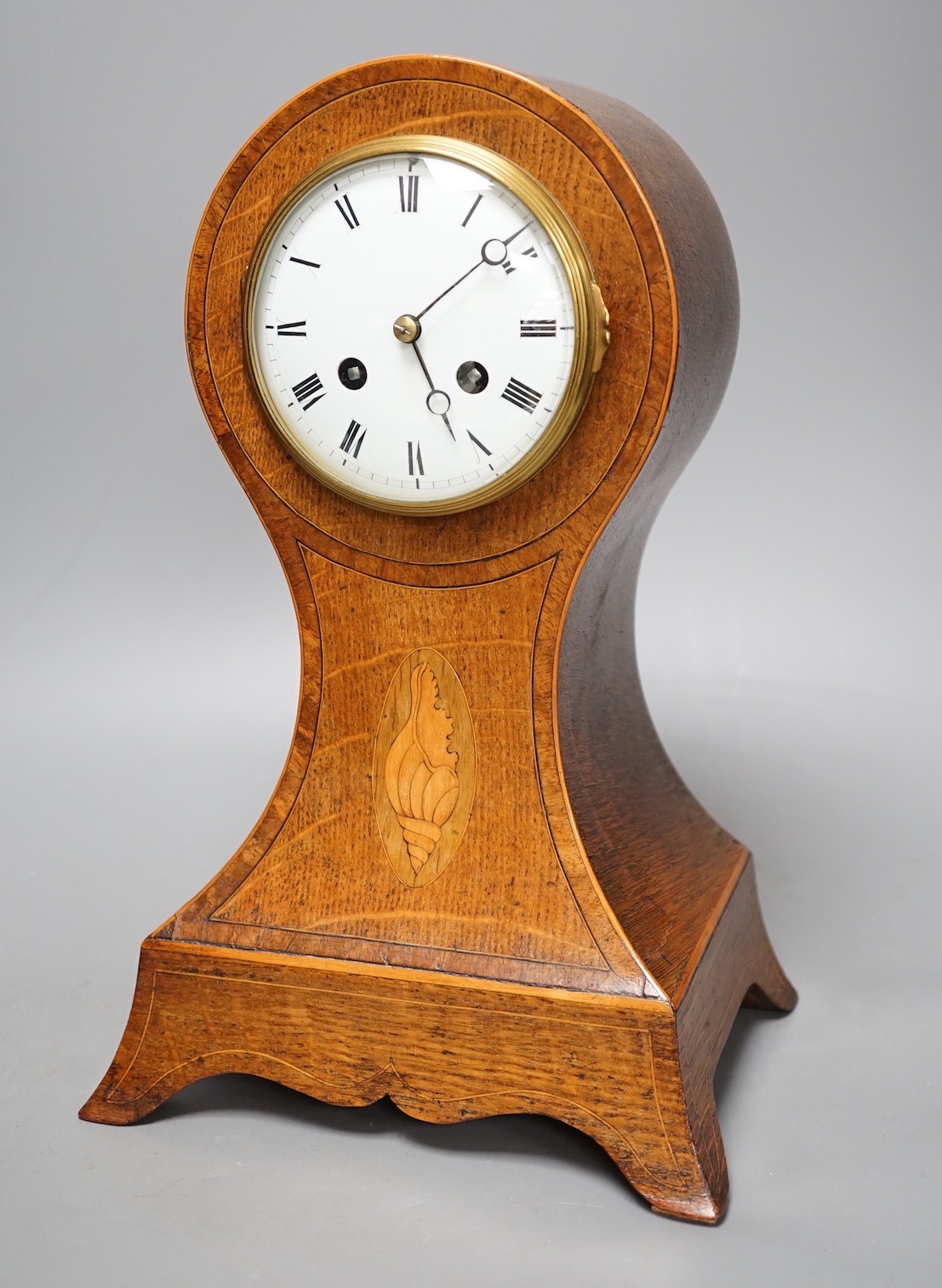 An Edwardian oak and marquetry balloon clock - 30cm tall